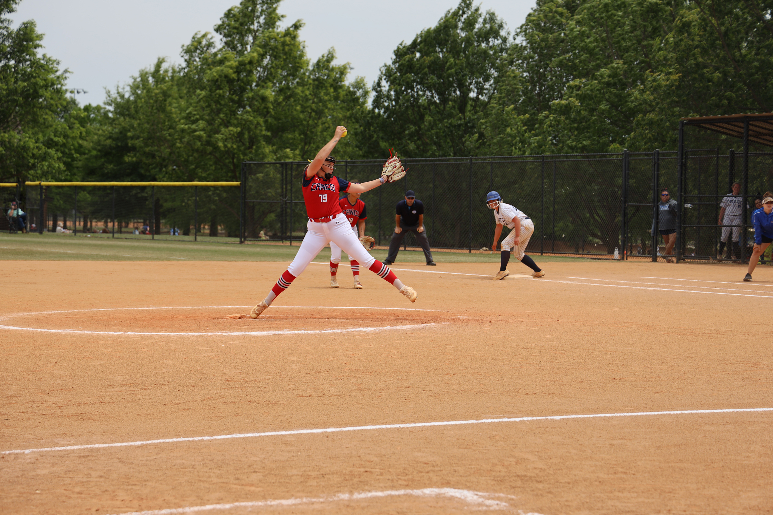 Louisburg College Softball pitchers winds up to deliver pitch.