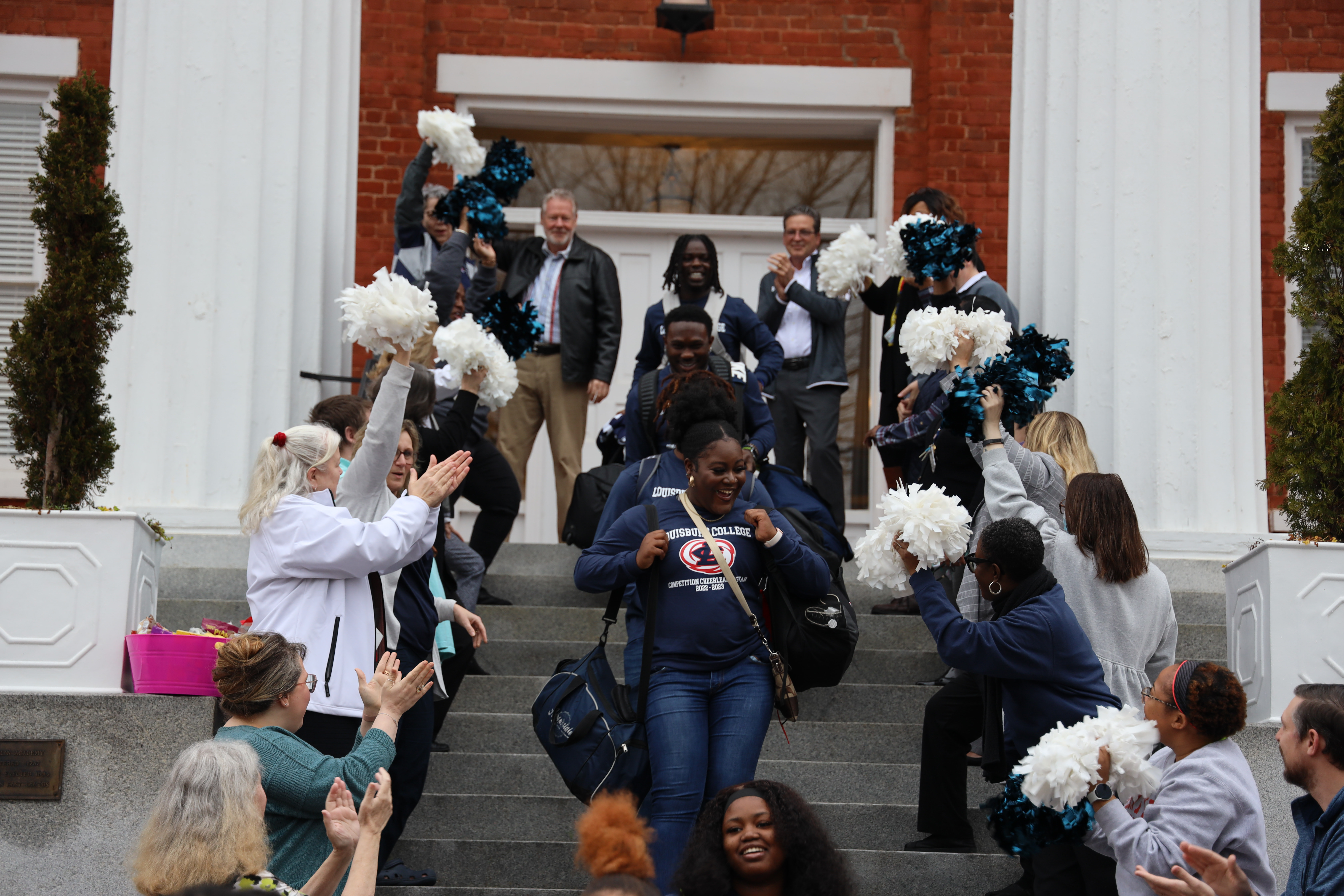 Cheerleading team leaving for nationals with administrators, faculty, and staff sending them off.