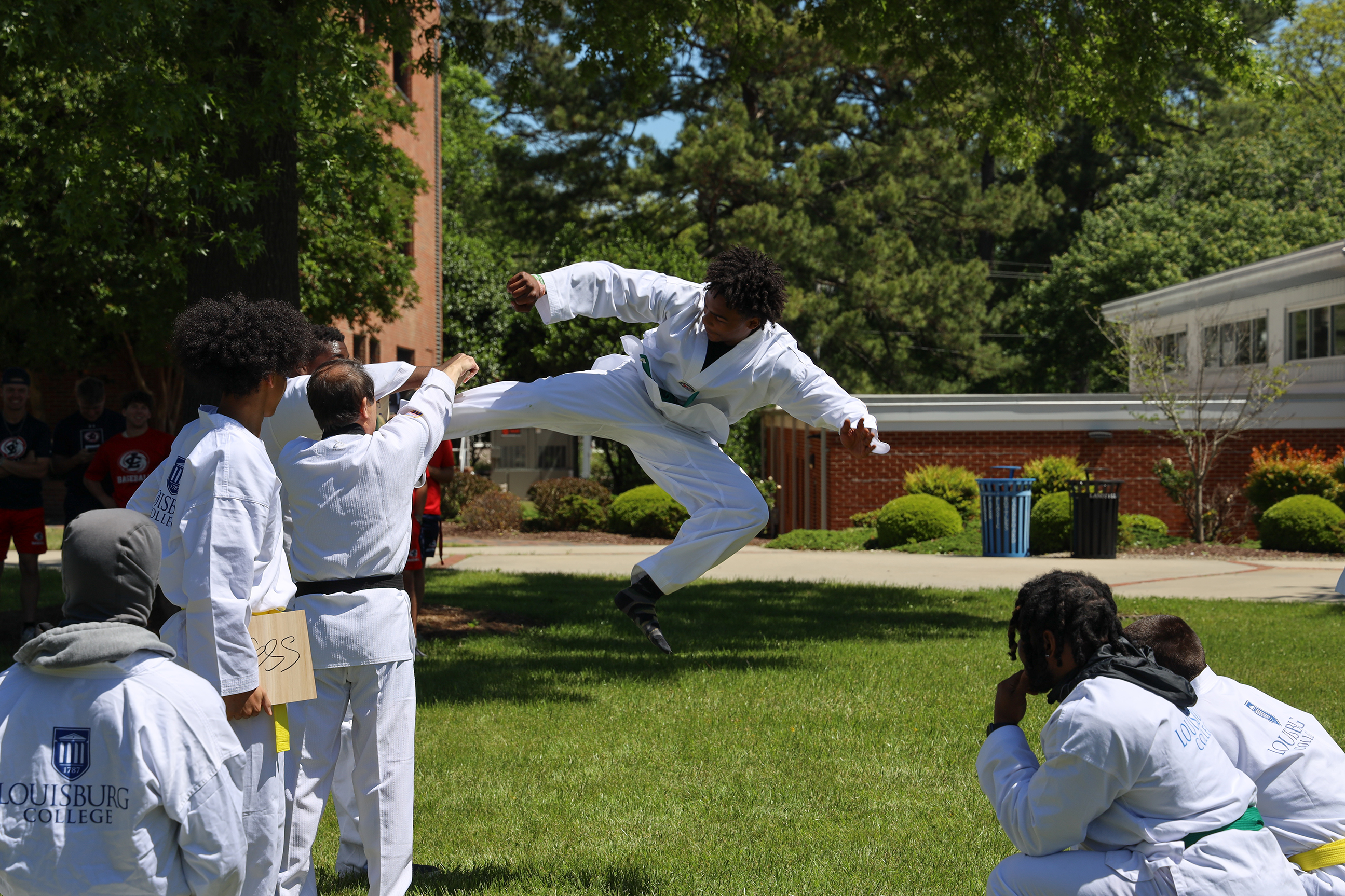 PED 125 Taekwondo presentation, student kicking board.