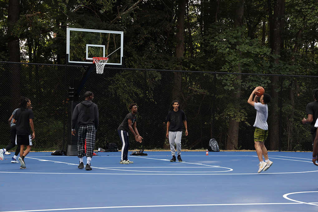 Students playing basketball on outdoor courts.